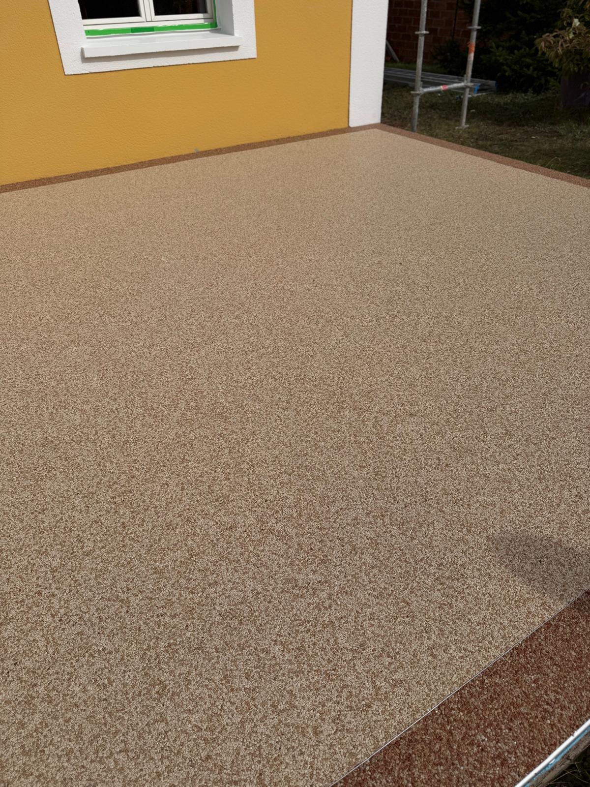 Terrasse en moquette de pierre beige avec bordure contrastée