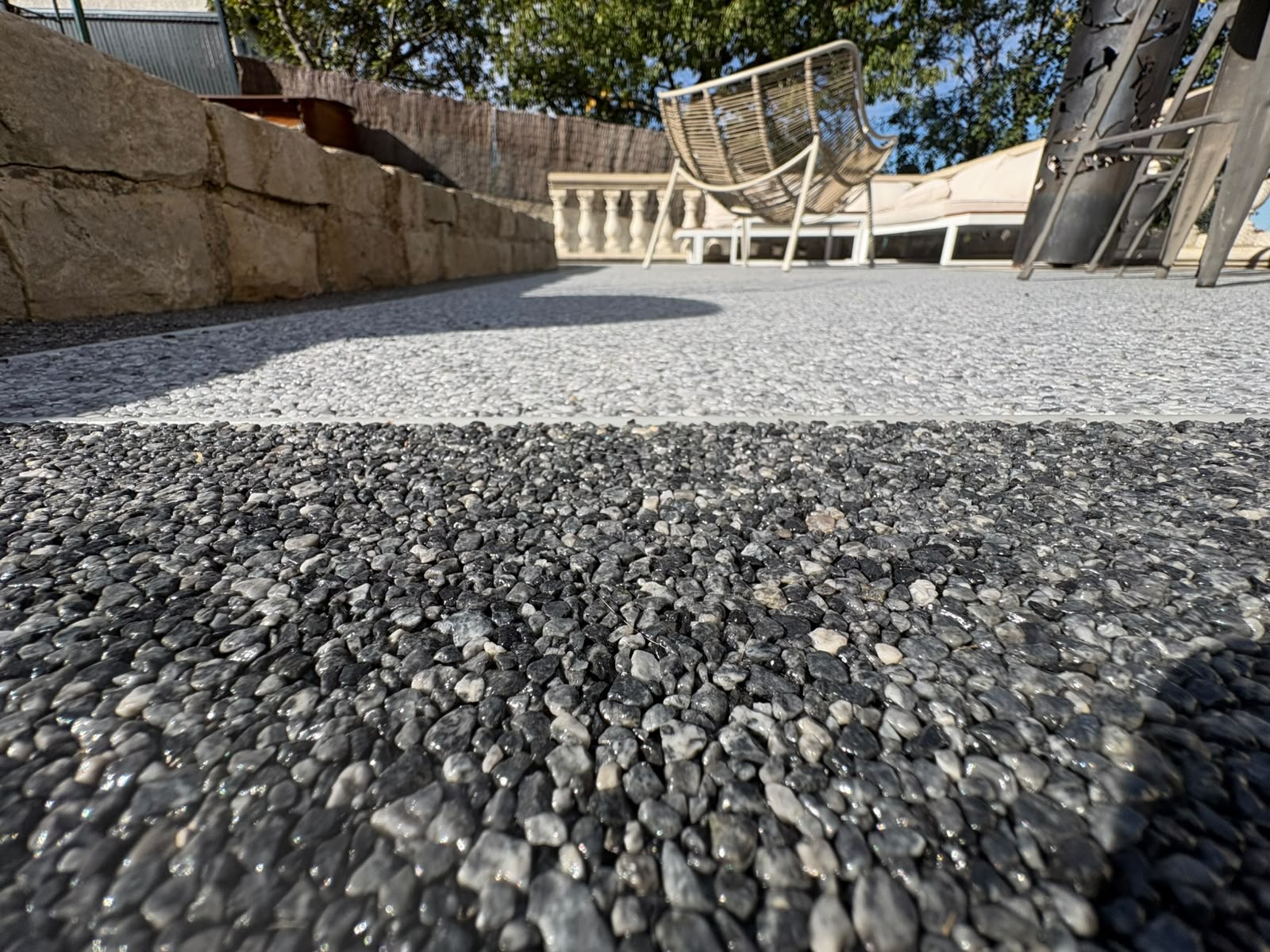 Détail des granulats gris et blancs d'une terrasse en moquette de pierre