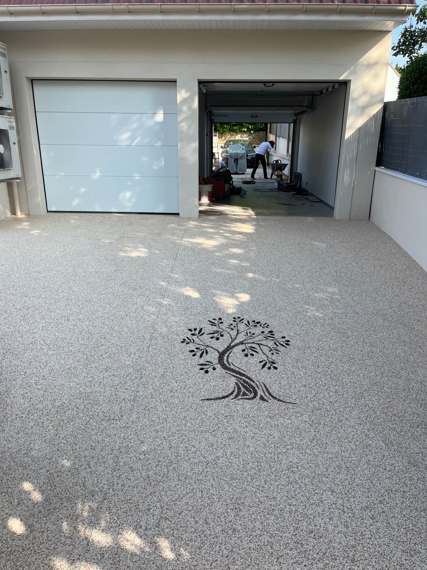 Allée de garage en moquette de pierre avec motif arbre