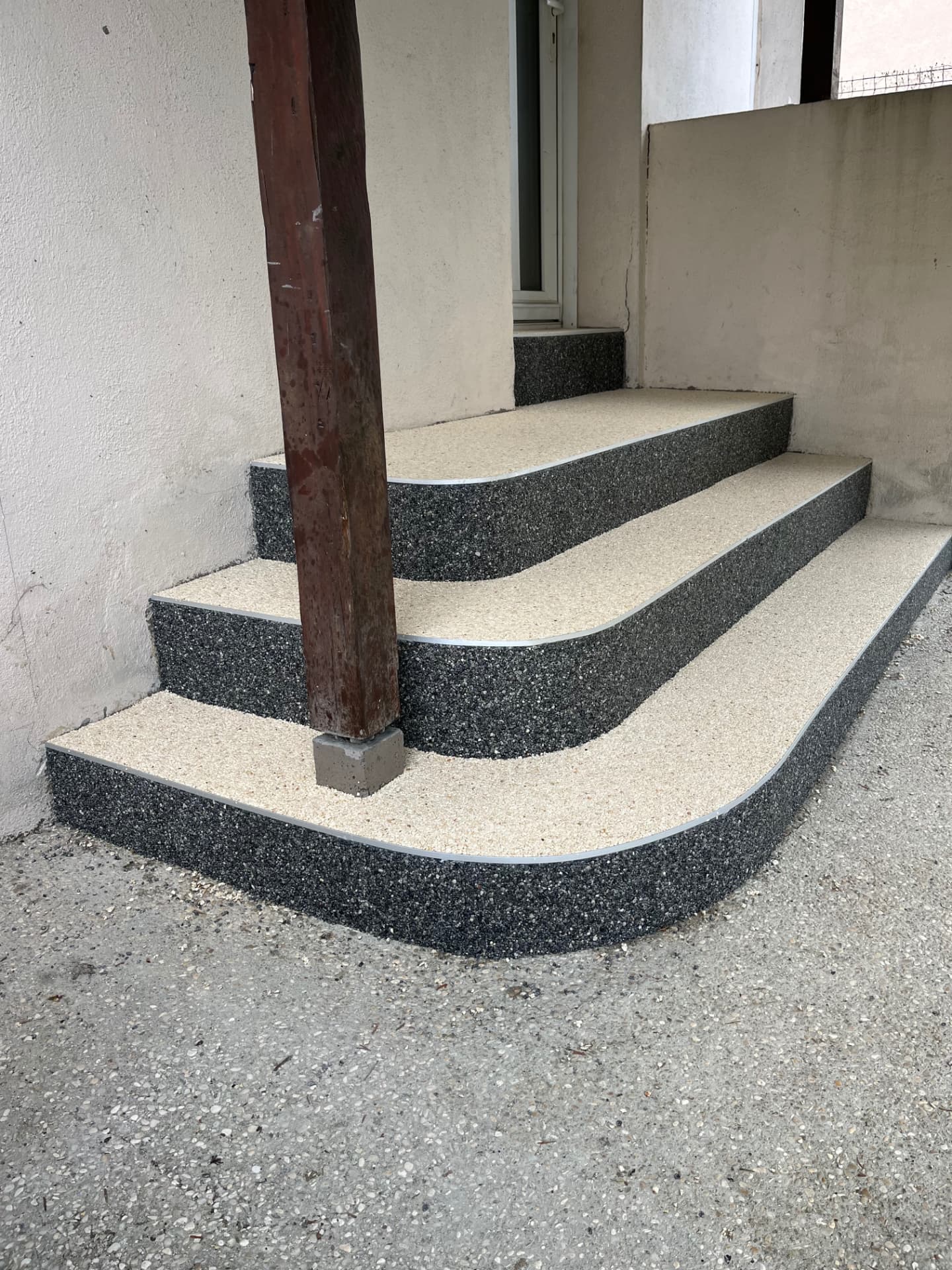 Escalier extérieur arrondi en moquette de pierre beige et noire