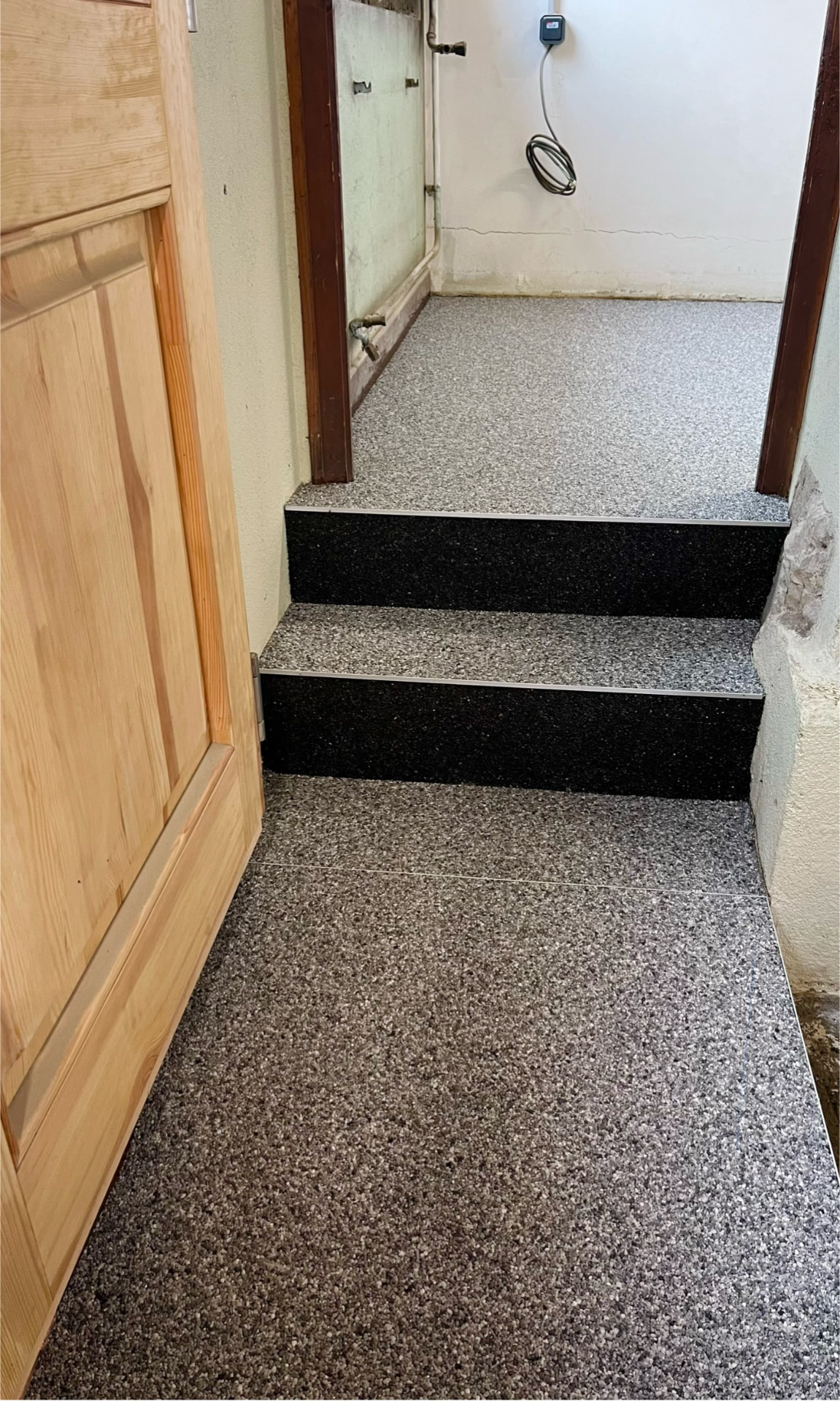 Escalier intérieur en moquette de pierre grise et contremarches noires