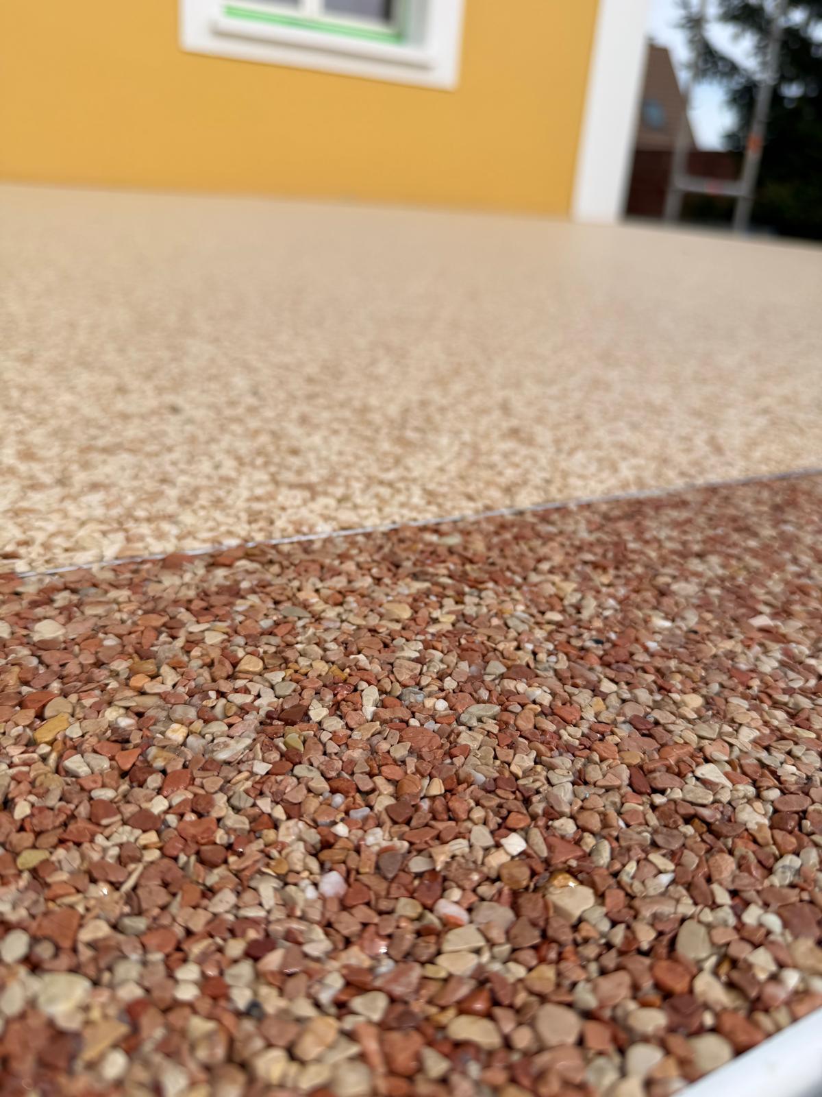Détail d'une bordure rouge et beige en moquette de pierre